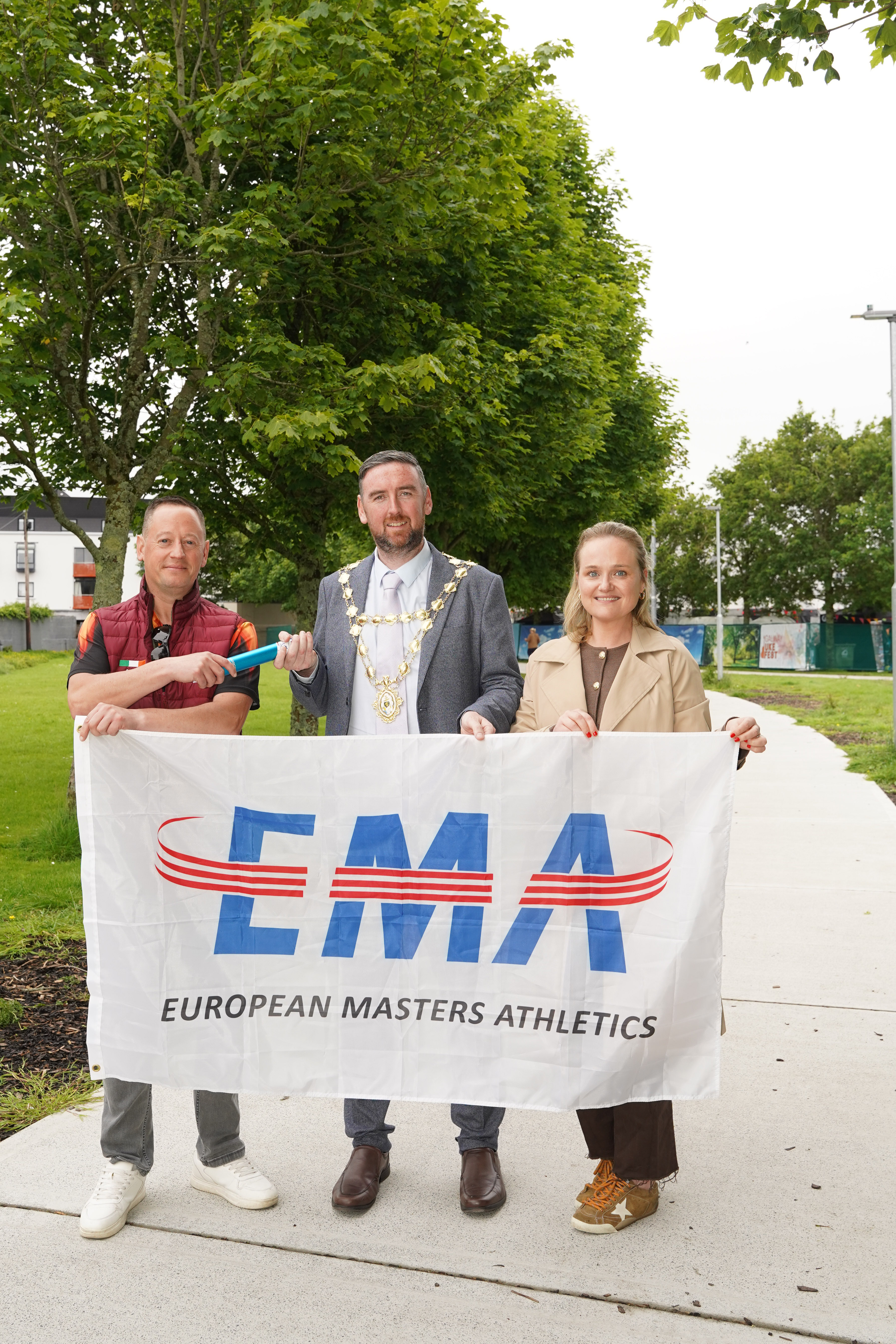 Stephen Monaghan, Mayor Cllr. Mike Cubbard, and Sally Ann O'Brien holding the European Masters Athletics flag in Galway